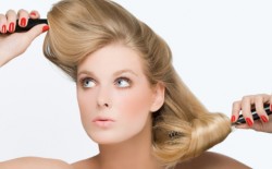 Young woman using hairbrushes